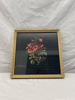 Front of vintage needlepoint framed artwork showing floral design.