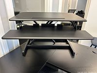 Front view of the black Airlift Seville Classics standing desk converter showing two-tier design with keyboard platform and monitor/laptop platform
