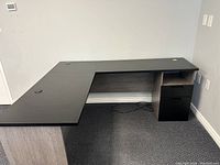 Front angled view of the right hand facing L-shaped executive desk showing work surface, drawers, and cable grommet