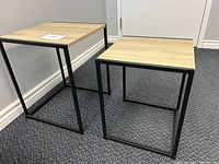 Two nesting tables side by side showing size difference and wood grain tops with black metal frames.