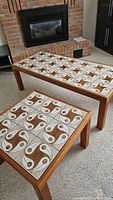 Photo showing both the coffee and end tables side by side, highlighting their tile inlay tops and wooden frames.