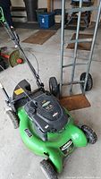 Front angle view of green Lawn Boy mower and appliance dolly in a garage setting