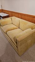 Side view of yellow velveteen loveseat in good condition showing fabric and cushions