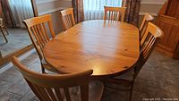 Front view of oval pine dining table with six chairs in kitchen