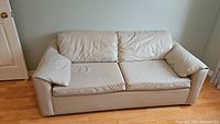 Front view of beige pleather sofa in couch form