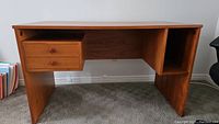 Front view of teak desk showing two drawers on left and open shelving on right