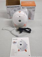 Two bark control devices in original packaging with instruction manual and USB cables displayed together.