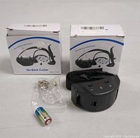 Two no bark collar boxes with one collar, accessory, and battery shown outside the box.