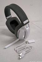 White and gray Binunne Bluetooth over-ear headphones alongside USB Bluetooth dongle and USB charging cable, front view