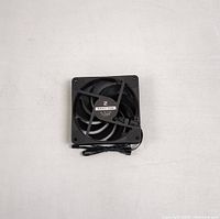 Top-down view of EZDIY-FAB black computer cooling fan showing fan blades and cable coiled on top.
