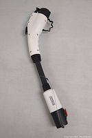 Photo of Lectron Tesla to J1772 EV charging adapter with the white and black ergonomic handle and connector.