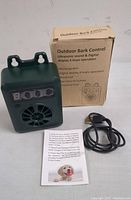 Photo showing the bark control device, USB charging cable, instruction manual, and product box.