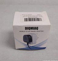 DIQMIAQ branded product box displaying the Type G travel adapter image showing the plug and socket profile for UK use.