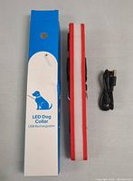 LED dog collar with USB charging cable and original packaging box on plain surface