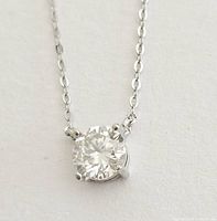 Close-up of the moissanite gemstone pendant set in sterling silver with a four-prong setting and delicate chain links.
