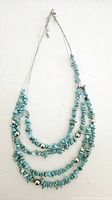 Full view of the 4-strand natural turquoise necklace showing overall design and chain.