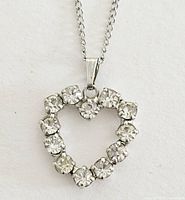 Close-up of the heart-shaped pendant showing the twelve clear cubic zirconia stones mounted on a sterling silver setting.