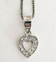 Close-up image of the heart-shaped pendant featuring small round diamonds set in .925 sterling silver on a box chain.