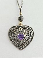 Close-up of the heart-shaped Gorham sterling silver pendant featuring intricate filigree work and a heart-shaped purple amethyst stone in the center.