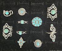 Top-down view of 12 Southwest-style turquoise and silver-tone fashion rings arranged in a tray
