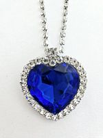 Close-up of blue heart-shaped pendant surrounded by clear rhinestones