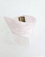 Photo showing one side of the vintage bubblegum pink Lucite wave bracelet with hinged clasp, highlighting the translucent swirled texture.