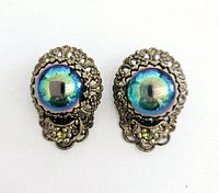 Front view of both clip-on earrings showing blue-green iridescent cabochons with silver-tone filigree and rhinestones.