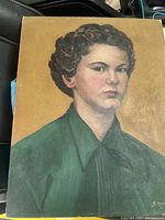 Portrait painting of a woman with curly dark hair in a green shirt, signed in bottom right corner