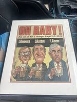 Framed political cartoon print with caricatures and text 'OH BABY!', showing condition and details of the artwork
