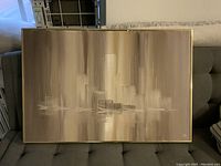 Full view of the abstract oil painting signed Esa, showing the painting on a gray sofa with a thin gold frame.