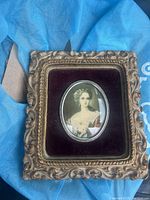 Front of ornate framed portrait featuring an oval image of a woman titled 'Lady Dower'