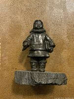 Bronze sculpture of standing Inuit figure on textured base