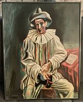 Framed signed print of a Picasso artwork showing a sitting clown figure with a mask and a book on a table in the background.