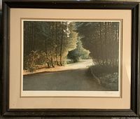 Front view of framed artwork showing a sunlit forest path with trees and greenery.