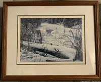 Framed print showing a pack of wolves in a snowy forest with visible artist signature and edition number.