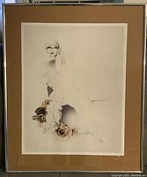Framed artwork under glass showing a stylized image of a woman with roses at the base.