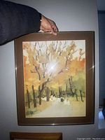 Photo of signed framed artwork showing impressionistic tree landscape with light earth tones.