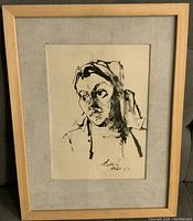 Front view of framed ink portrait drawing of a woman signed 1962.