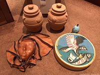 All items shown together on carpet with visible details of mask, jars, tambourine, and egg-shaped container.