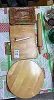 Top view of wooden cutting board, ceramic Niagara Falls dish, wooden rolling pin, and round wooden spinning board arranged on a table
