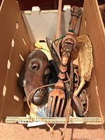 Box with carved wooden mask, carved wooden utensils, woven fan and smaller wooden objects