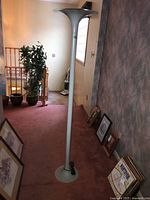 Full view of lamp standing on carpeted floor against wall