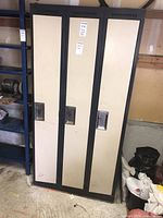 Full view of the closed metal locker showing three beige doors with dark frames and metal handles.