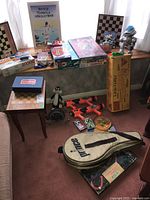 Overview of all games and toys displayed on floor and chairs showing the variety of items and their condition