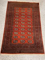 Full view of the rectangular hand woven wool rug showing the overall pattern and colors.