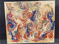 Close up of Dutch marble style painting with vibrant swirling patterns and colors framed in a dark wood float frame.