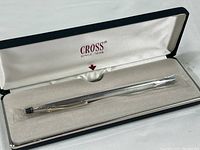Silver plated ballpoint pen in white cushioned box with satin lid lining showing the Cross logo and brand since 1846.
