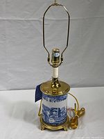 Full view of the Spode blue and white ceramic table lamp with brass top and base hardware, electric cord attached, no shade or finial.