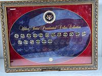 Full view of the framed U.S. Presidential Dollar Collection with some coins missing and decorative gold frame