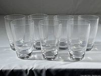 Seven clear crystal highball glasses arranged in two rows, showing overall group of glasses.